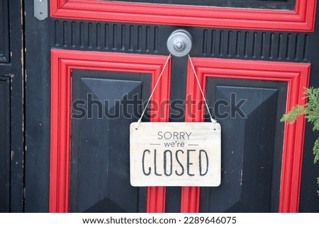 Sorry we are closed sign board wooden panel hanging on door of cafe 