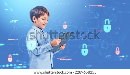 Happy boy play video games with tablet in hands. Lock hud hologram and dashboard with data security protection and statistics. Concept of safe internet for kids and parental control