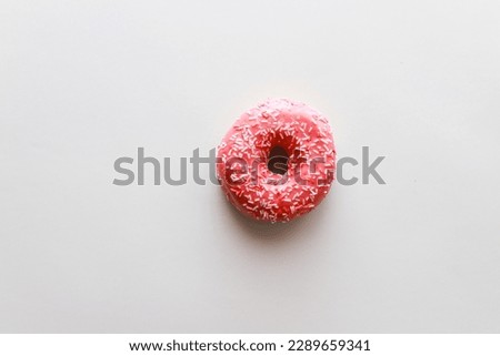 Pink donut on pink background flat lay