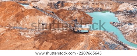 Behold the power of mining with this photo of a massive excavator at work in a titanium quarry. Witness the strength and might of modern machinery in action Royalty-Free Stock Photo #2289665645
