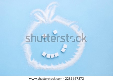 sugar face smile from sugar cubes without one tooth on a blue background, junk food Royalty-Free Stock Photo #2289667373