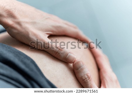 Man's hands make a heart shape with his hands on a pregnant belly. Husband or partner in anticipation of a baby together with his wife or spouse. Maternity, family, concept. Close up, shot from above. Royalty-Free Stock Photo #2289671561