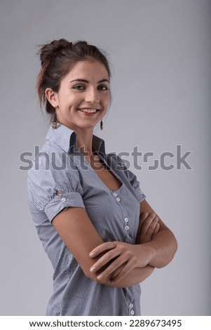 A half-body portrait of a young woman smiling with her arms crossed. She exudes confidence and pride in her competence, intelligence, erudition, and specialized knowledge that has enabled her to accum Royalty-Free Stock Photo #2289673495