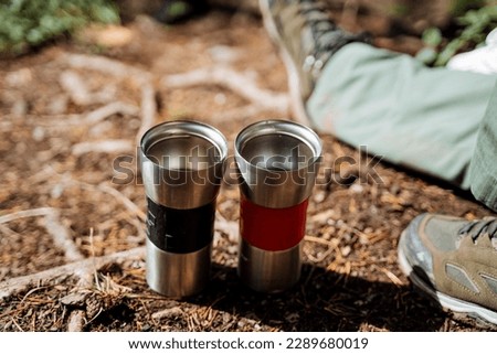 Tourist utensils thermo mug, glass for hot drinks, vacuum utensils, cup for tea, hiking in the forest for nature, camping in the forest. High quality photo