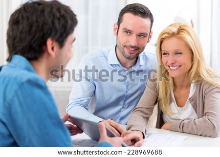 View of a Young attractive couple signing contract on tablet