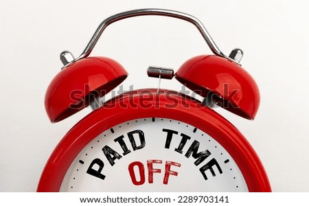 Red alarm clock with text Paid Time Off Royalty-Free Stock Photo #2289703141