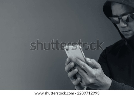 cybercrime committed by unauthorized users.He uses a mobile device to access a target's website. Royalty-Free Stock Photo #2289712993