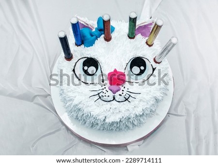 beautiful white cat cake with candles at a children's birthday party top view. kids party