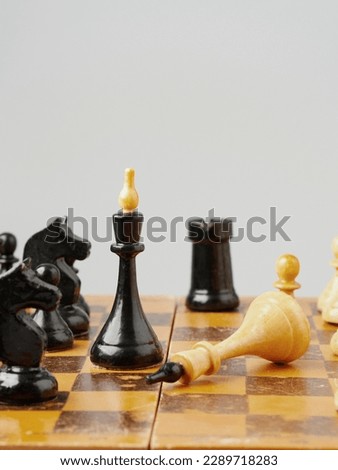 chess piece stand in front of pawn on black background    