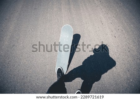 Asian woman skateboarder skateboarding on country road