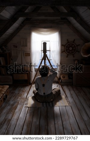 Children play in the attic of their house. Imagine themselves as tourists, explorers. Look through a telescope, study a world map, play in a makeshift tourist tent. Dreaming of travel and adventure. Royalty-Free Stock Photo #2289729767