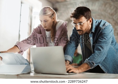 Two architects cooperating while working on a computer in the office