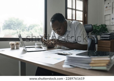 African American man calculating using machine managing household finances at home, focused biracial male make calculations on calculator account taxes or expenses Royalty-Free Stock Photo #2289761619