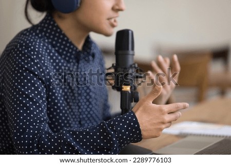 Close up young woman blogger in headphones lead livestream online chat with subscribers, provide information, share experience with channel followers. Livestream event, radio host employee workflow Royalty-Free Stock Photo #2289776103