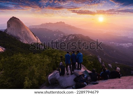 Photographer is taking a photo of the sunrise in the morning on  Bukhansan mountains , Seoul, South Korea.