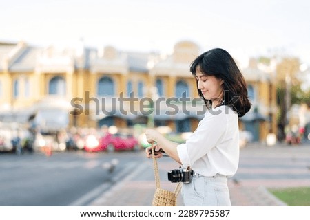 Portrait of young beautiful woman with camera explore street in Bangkok, Thailand