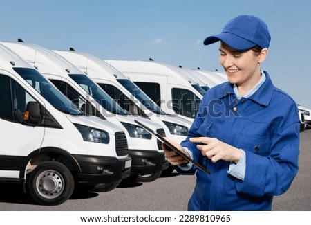 Manager with a digital tablet on the background of vans. Fleet management Royalty-Free Stock Photo #2289810965