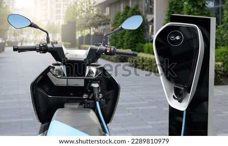Electric scooter with charging station on a city street. Royalty-Free Stock Photo #2289810979