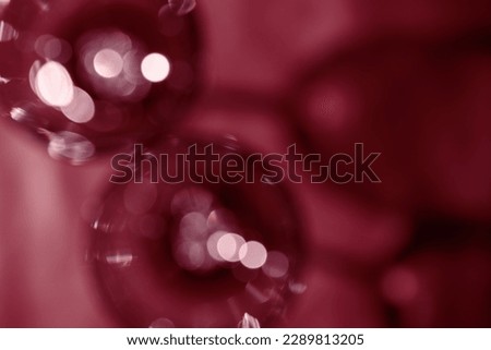 Wine glasses defocused, red wine color blurred background with light flare, optical blur, bokeh. Top view aesthetic still life photo alcoholic drinks art styles for winery, wine list, copy space.