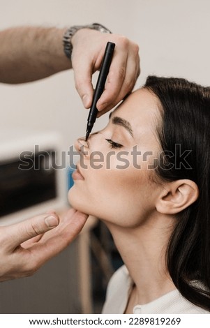 Rhinoplasty markup drawing lines on nose before surgery. Rhinoplasty is reshaping nose surgery for change appearance of nose and improve breathing Royalty-Free Stock Photo #2289819269
