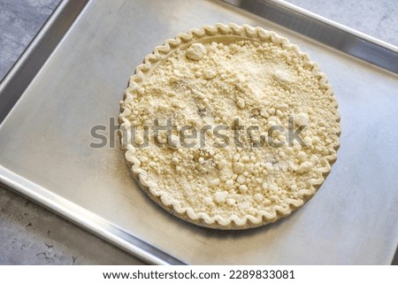 Top view of a premade store bought frozen Dutch apple pie on top of a baking sheet ready to be bake. Royalty-Free Stock Photo #2289833081