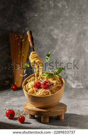 Pasta with parmesan and tomato sauce in a wooden bowl. floating Homemade Italian spaghetti - levitation photography  Royalty-Free Stock Photo #2289833737