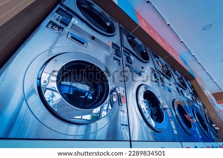 Rows of industrial laundry machines in the large laundromat. Royalty-Free Stock Photo #2289834501