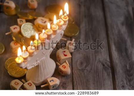 Jewish holiday hannukah symbols - menorah, chocolate coins and wooden dreidels. Copy space background.