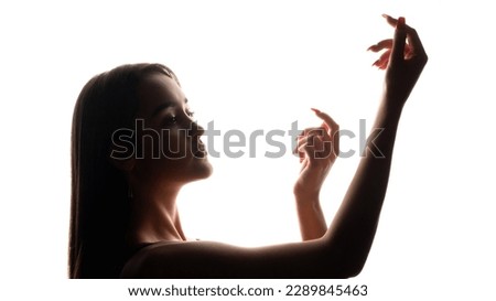 Female grace. Hand dance. Skin care model. Beauty wellness. Dark backlit profile of woman face arms silhouette on white free space.