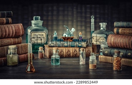 Glass bottles, old books on table of a scientist. Medicine, chemistry, pharmacy, apothecary, alchemy history background. Translation from labels-eyewash astringent, morphine hydrochloride and almonds. Royalty-Free Stock Photo #2289852449