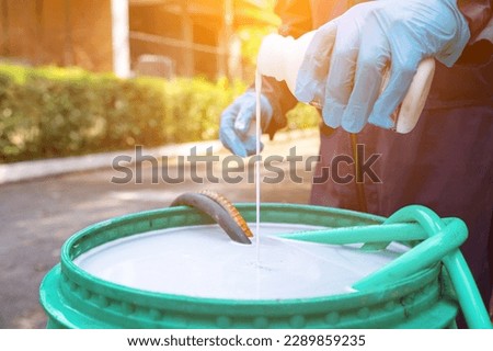 exterminate termite control company employee is using a termite sprayer at customer's house and searching for termite nests to eliminate. exterminate control worker spraying chemical insect repellant Royalty-Free Stock Photo #2289859235