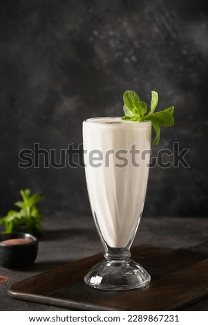 Indian Salty lassi with mint leaves and kala namak on black background. Traditional healthy freshness lassi made of yogurt, water, spices and ice. Vertical format. Royalty-Free Stock Photo #2289867231