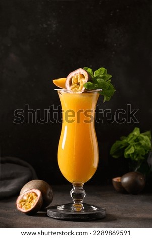 Passion Fruit and mango juice in hurricane glass on black background. Vertical format. Traditional healthy drink with mango. Freshness lassi made of yogurt, water, spices, fruits and ice. Royalty-Free Stock Photo #2289869591