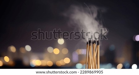 fragrant sticks smoke on blurred background of night sky Royalty-Free Stock Photo #2289869905