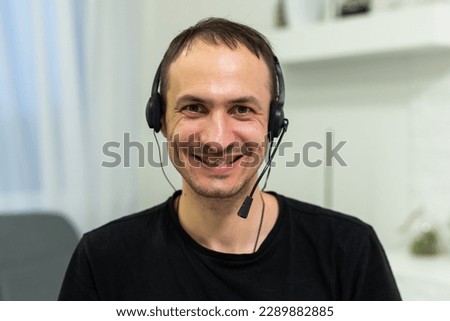 Smiling young man working on laptop in modern kitchen, checking email in morning, writing message in social network, happy young male using internet banking service, searching information Royalty-Free Stock Photo #2289882885