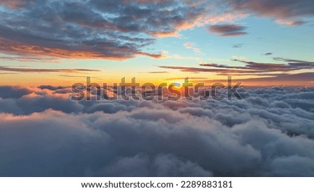 Epic sunset over the clouds. Flight in the sky at sunset, view from window of airplane. Warm sun sets over the horizon in clouds Royalty-Free Stock Photo #2289883181