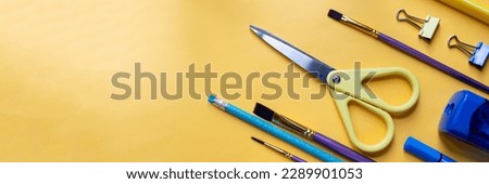Frame from school and office supplies Paper clips, scissors, pens, felt-tip pens, sharpener, isolated on yellow background. Flat lay.Back to school, education concept.Teacher's Day. Royalty-Free Stock Photo #2289901053