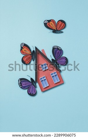 House floating in the sky with butterflies. Real estate investment concept. Flying dream and hope. Flying high for property company. Hand made of paper quilling technique.