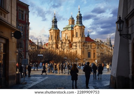 Prague, Czech Republic. View at the Saint Nicholas Church Staromestska square in centre of Prague Old Town. Evening sunset and people walking by street Royalty-Free Stock Photo #2289909753