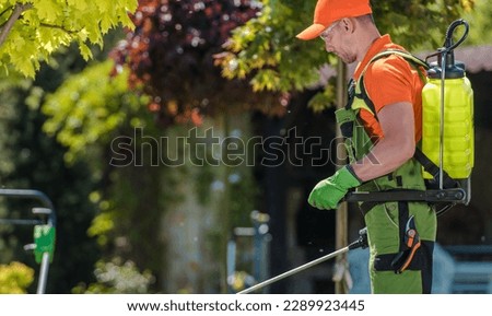 Side View of Caucasian Gardener Spraying Pesticides in the Garden Using Pump Sprayer. Agricultural Theme. Royalty-Free Stock Photo #2289923445