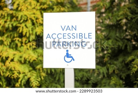The blue handicap sign on the street is a universal symbol for accessibility and mobility aid for individuals with disabilities, representing equal opportunities and inclusion.