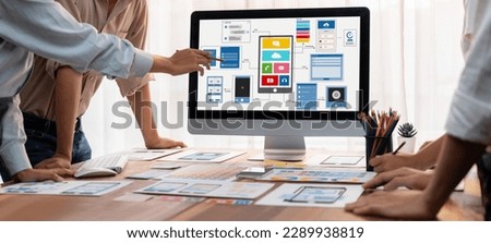 Panorama shot of front-end developer team brainstorming UI and UX designs for mobile app on laptop computer screen. User interface development team planning for user-friendly UI design. Scrutinize Royalty-Free Stock Photo #2289938819