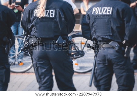 German police squad formation in protective gear with "Police" logo on uniform maintain public order after football game and political protest rally in the streets of Berlin city center, Germany
