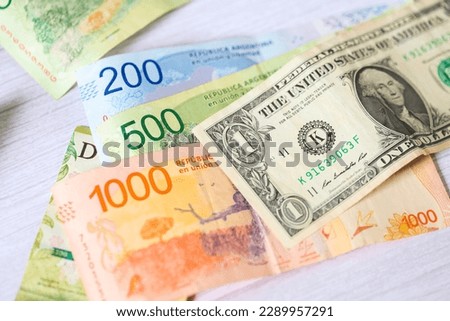 A one dollar bill from the United States with notes of money from Argentina.
 Royalty-Free Stock Photo #2289957291