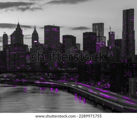 Purple lights shining in black and white cityscape with the downtown Manhattan skyline buildings of New York City at night time
