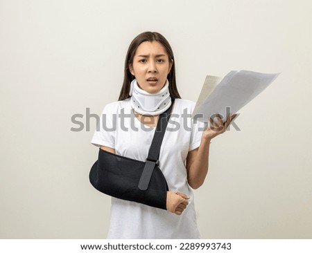 Depressed upset woman suffering from pain with bill payment No money to pay for medical care. Broken arm. woman put on plaster cast splint. Patient wearing sling support arm. Royalty-Free Stock Photo #2289993743