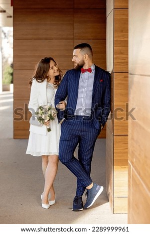 Young newlywed couple, having pictures taken on their wedding outdoors, springtime