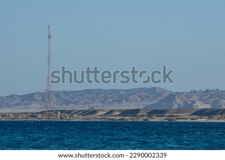 high antenna at the beach with deep blue water and high mountains in egypt