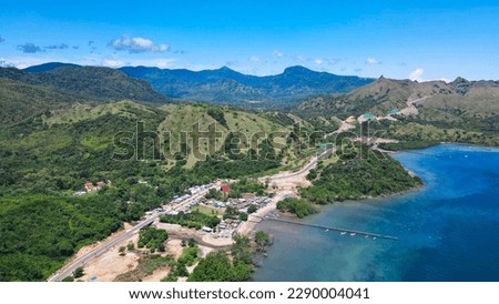 Golo Mori – Labuan Bajo Super Premium Tourism Destination where Asean Summit will implement. Aerial view of a road in green meadows and hills with beach and mountains. Royalty-Free Stock Photo #2290004041