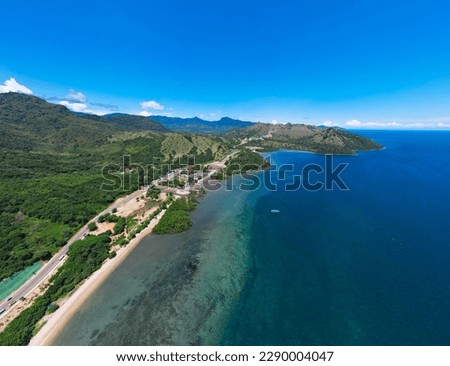 Golo Mori – Labuan Bajo Super Premium Tourism Destination where Asean Summit will implement. Aerial view of a road in green meadows and hills with beach and mountains. Royalty-Free Stock Photo #2290004047